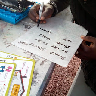 A young person practices English by writing out words on a piece of paper