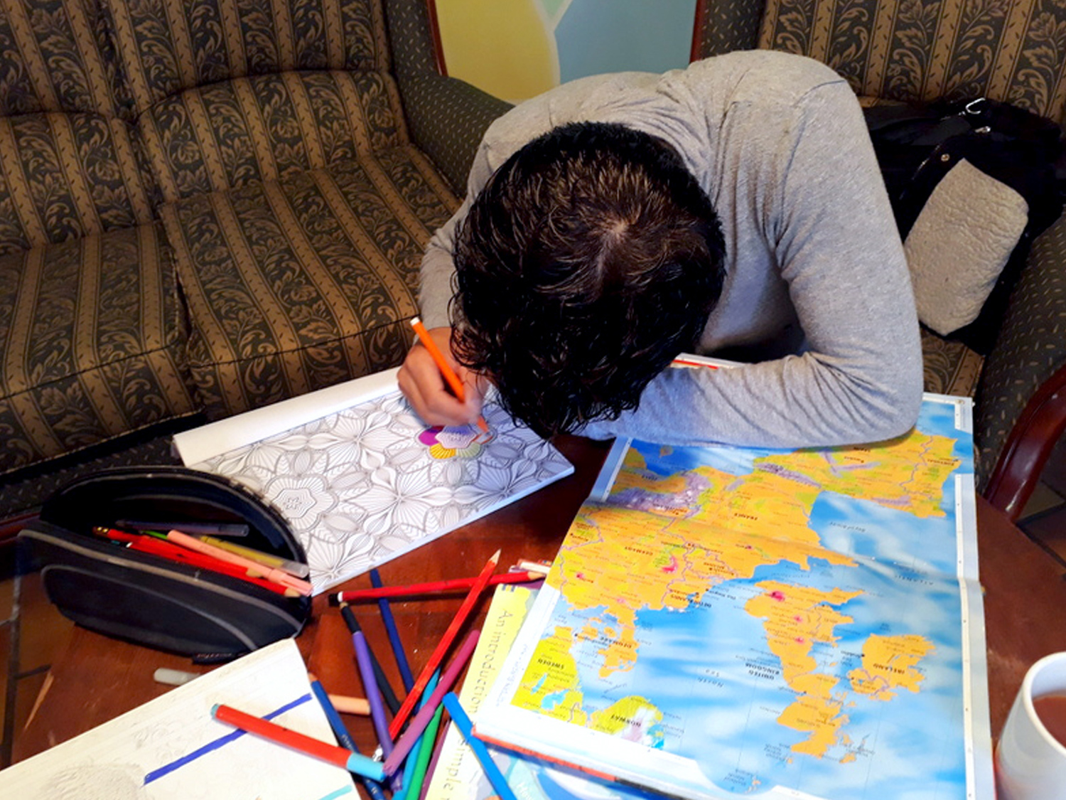 Child colouring in with a map of Europe